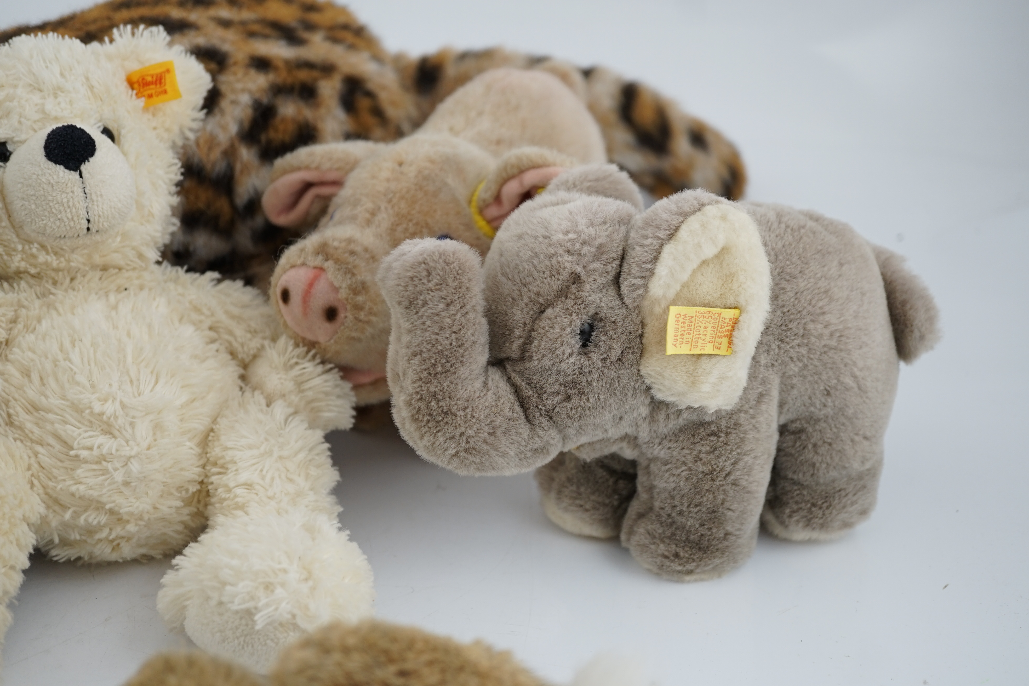 A large size Steiff yellow tag leopard, eight yellow tag animals, a Steiff button in the ear book and a book of Steiff postcards